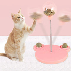 Cat playing with a pink cat toy that has a spinning top and food treats on a white background.