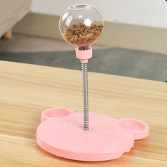 Pink pet toy with a transparent ball containing treats on a wooden surface
