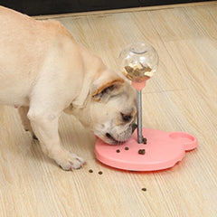 Dog interacting with a pink pet toy on a wooden floor
