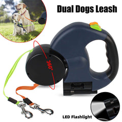 Retractable dog leash with LED flashlight feature, shown with two dogs on a grassy field.