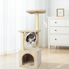 Cat playing with a toy inside a multi-level cat tree in a room with white furniture.