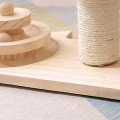 Cat playing with a green and wooden cat toy on a wooden floor.